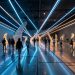Grande salle d’exposition immersive contemporaine, avec des jeux de lumière et des visiteurs en mouvement, ambiance artistique et éclairage cinématographique.