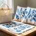 Atelier créatif dans un appartement montrant un tote bag en coton et des housses de coussin décorés de motifs botaniques cyanotype bleus.